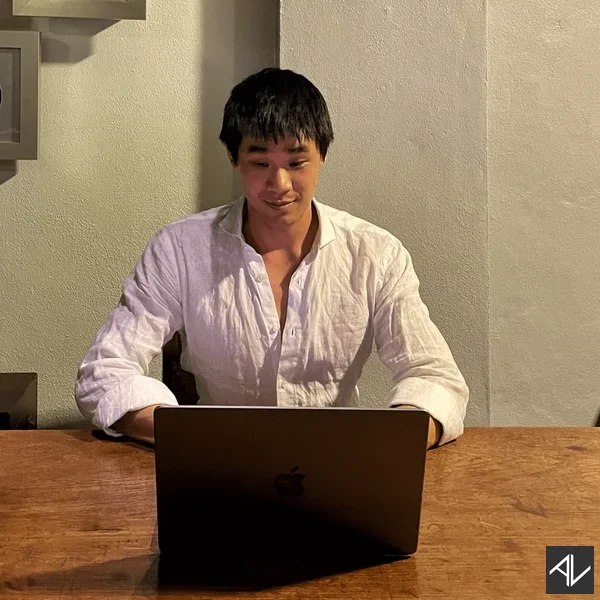 Aaron Lynn working on a laptop at a wooden table